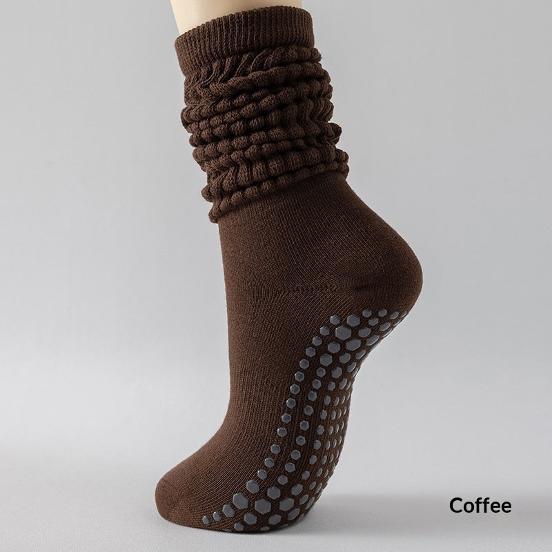 Brown sock with textured top and grip sole on a gray background