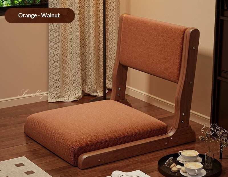 Brown wooden chair with cushion on a wooden floor, next to a tray with tea set.