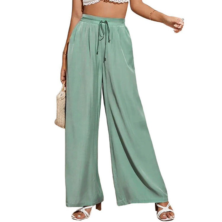 Green wide-leg pants worn by a person on a white background