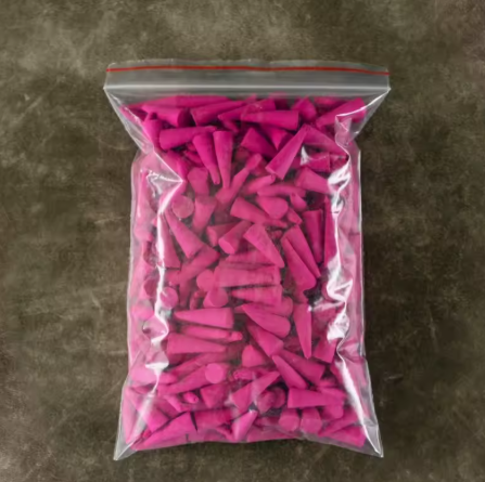 Clear plastic bag filled with pink objects on a brown surface