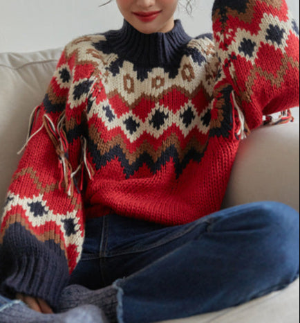 Person wearing a red and patterned sweater sitting on a couch.