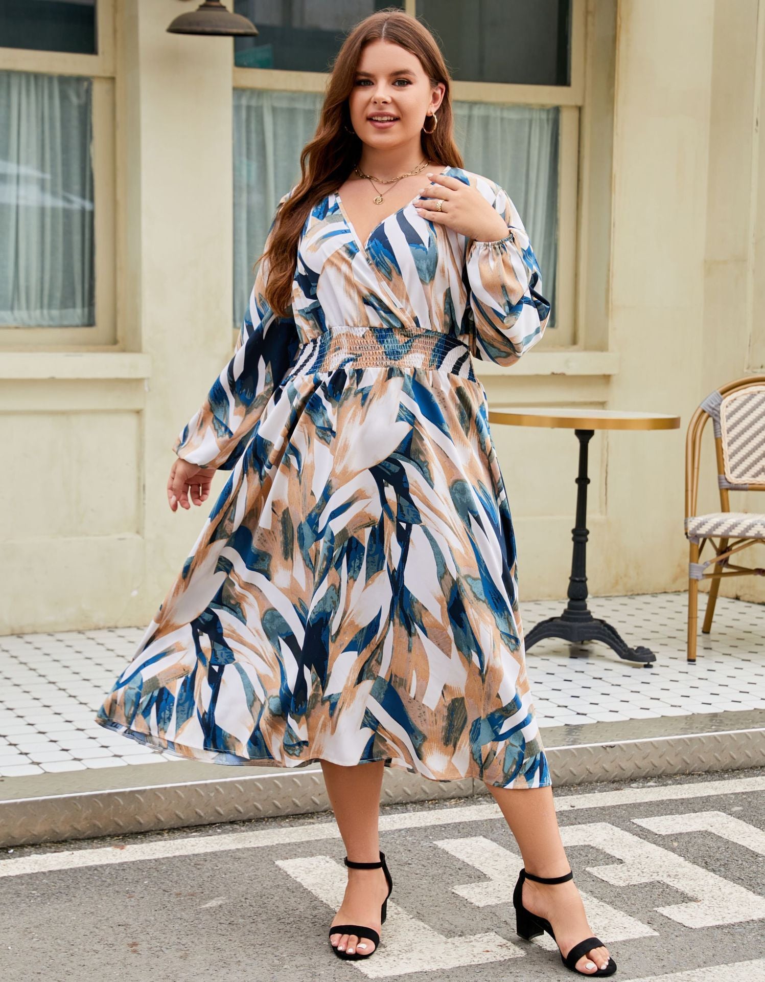Woman wearing a patterned dress standing on a street with a building in the background
