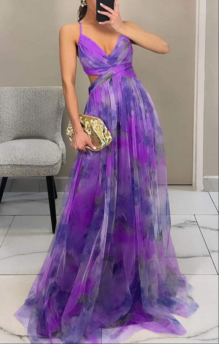 Woman wearing a purple evening gown with a gold clutch in a room.