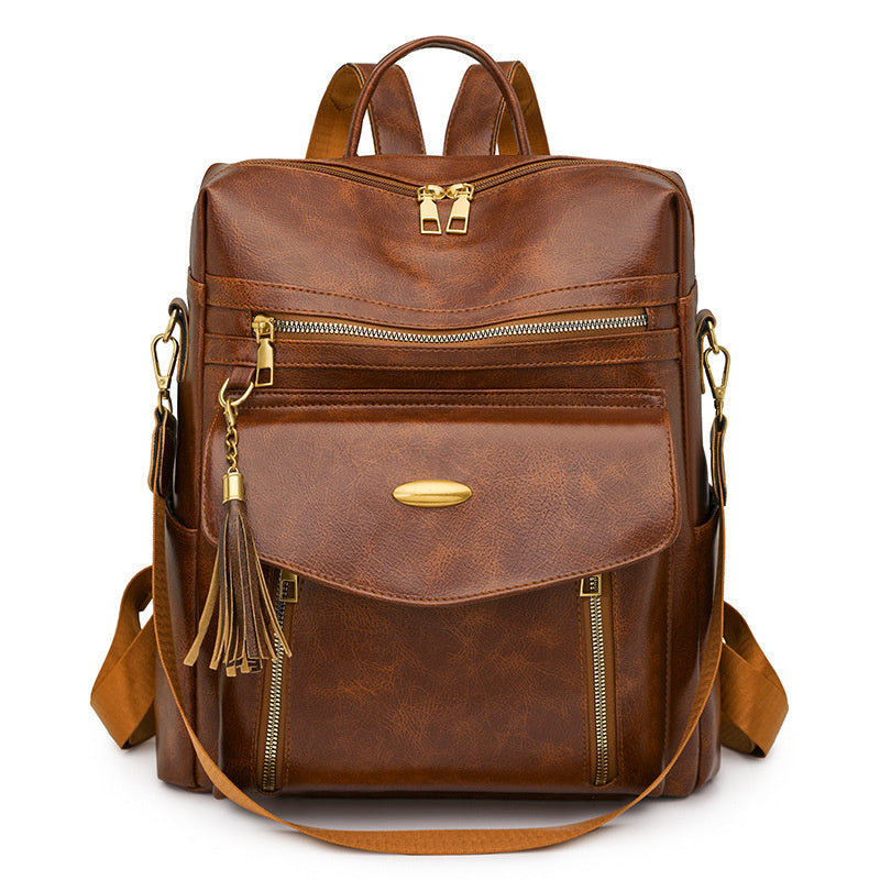 Brown leather backpack with gold accents on a white background