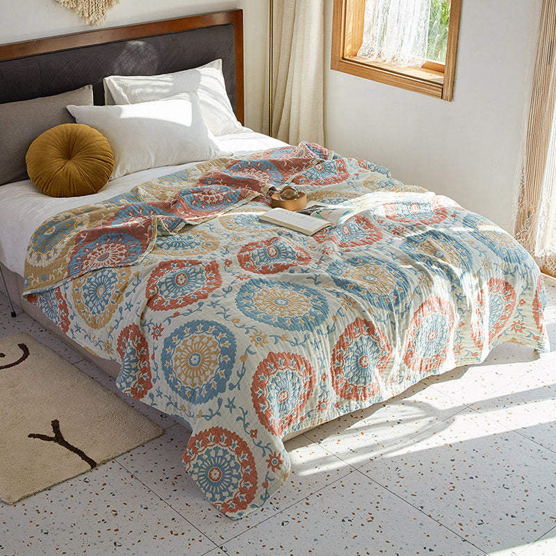 Bed with a patterned comforter in a bright bedroom