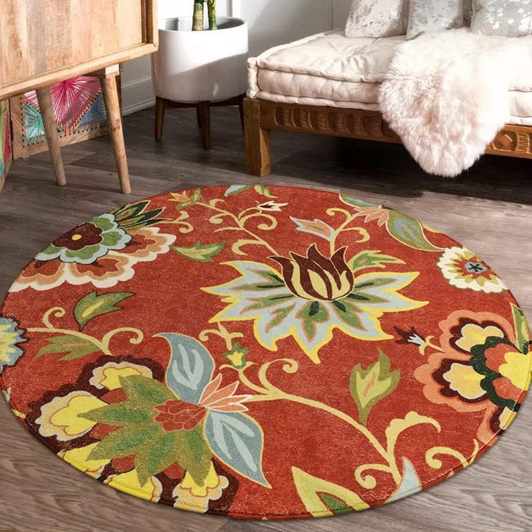 Round floral-patterned rug on a wooden floor with a couch and side table in the background.