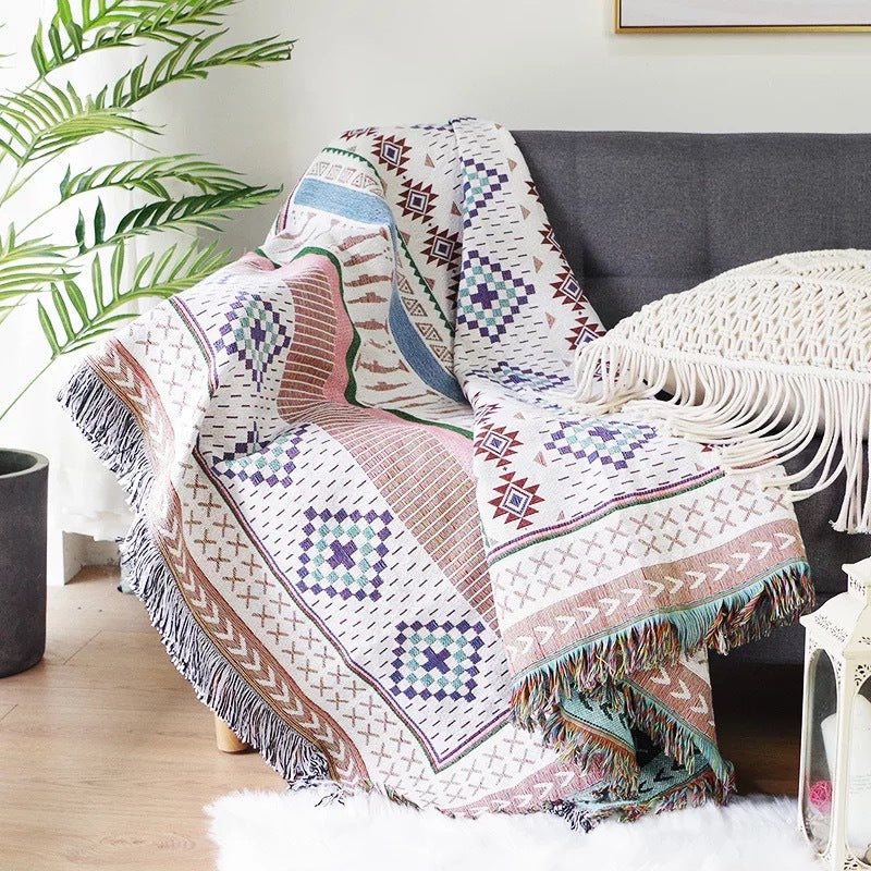 Decorative blanket with geometric patterns draped over a chair in a living room setting.