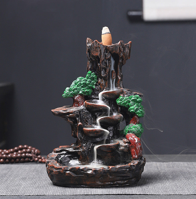 Decorative incense burner with a waterfall design on a dark background