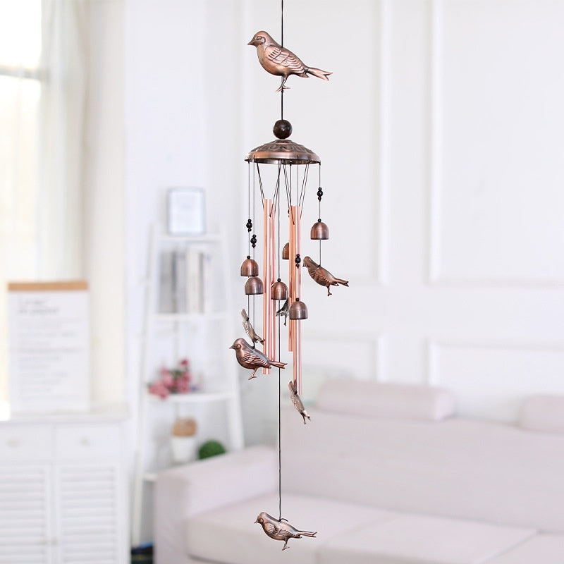 Decorative wind chime with bird designs in a room setting