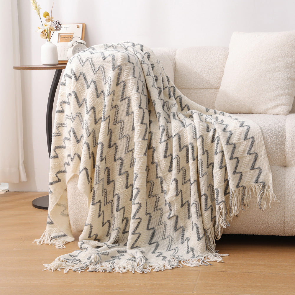 Patterned blanket draped over a sofa in a living room setting
