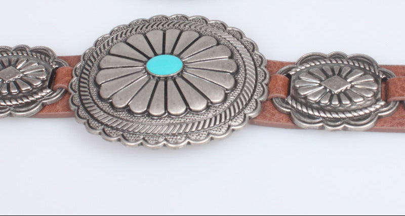 Belt with silver concho-style fastenings and turquoise stones on a white background
