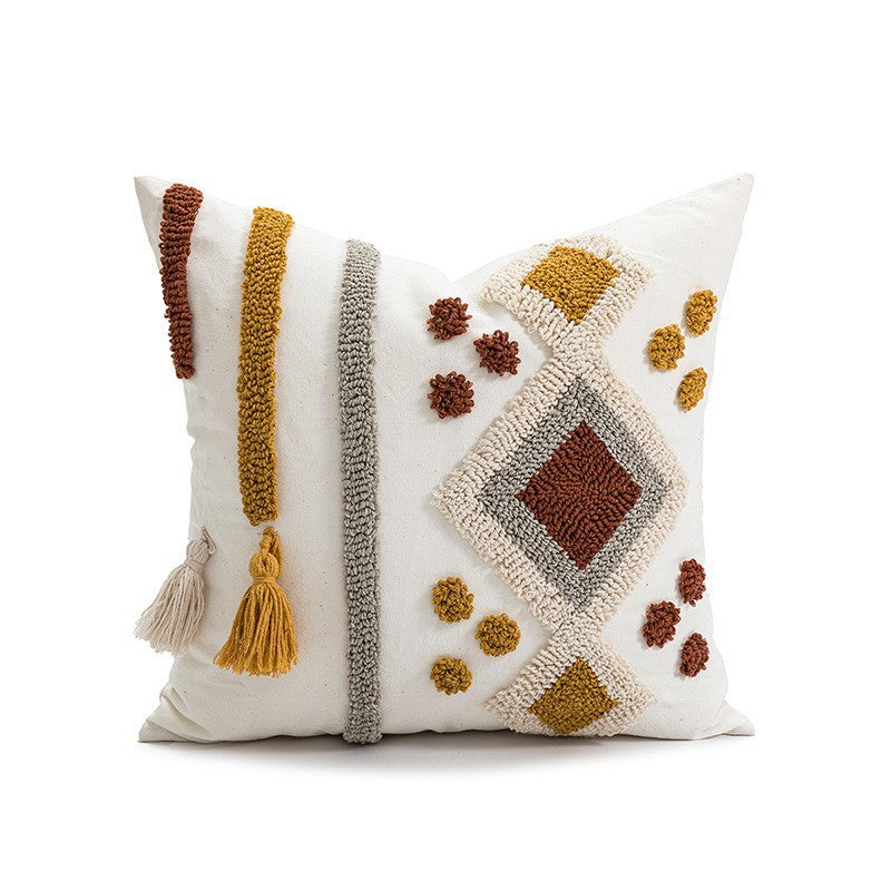 Decorative pillow with geometric patterns and tassels on a white background