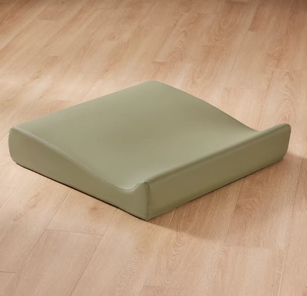 Green wedge cushion on a wooden floor