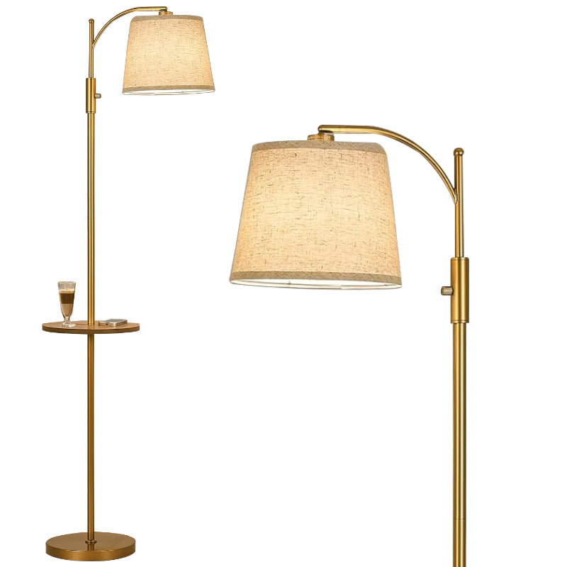 Gold floor lamp with a beige shade on a white background