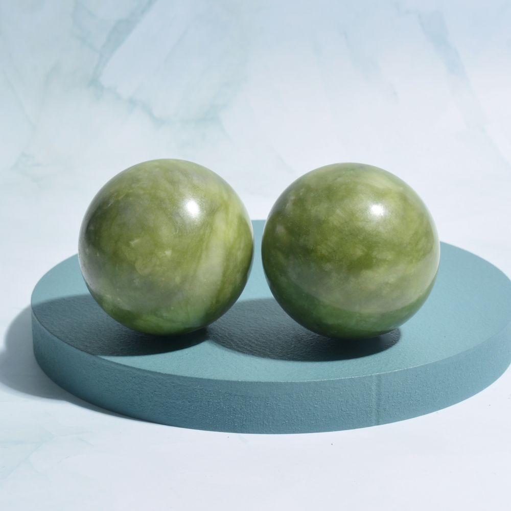 Two green spherical objects on a blue platform with a light blue background