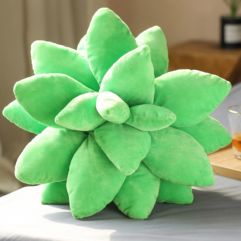 Green succulent-shaped pillow on a surface with a blurred background