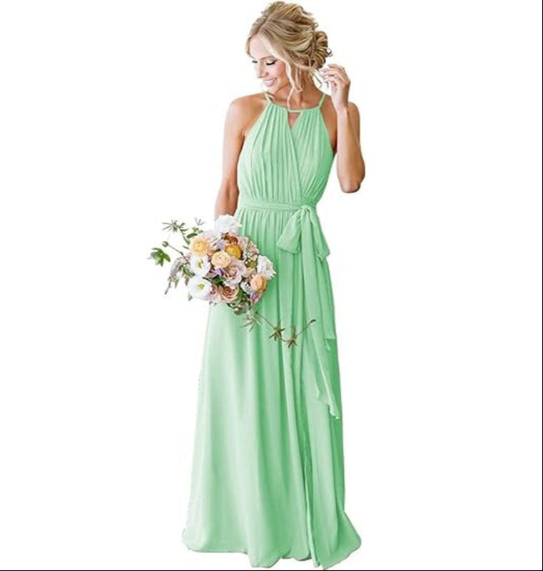 Woman in a light green dress holding a bouquet of flowers on a white background