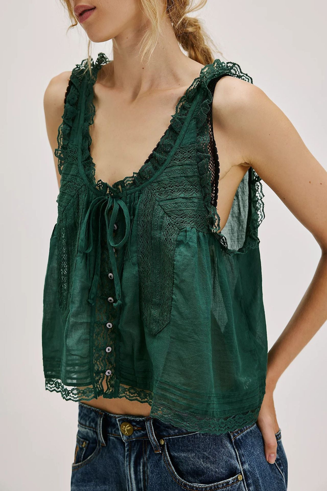 Green lace tank top worn by a person on a plain background