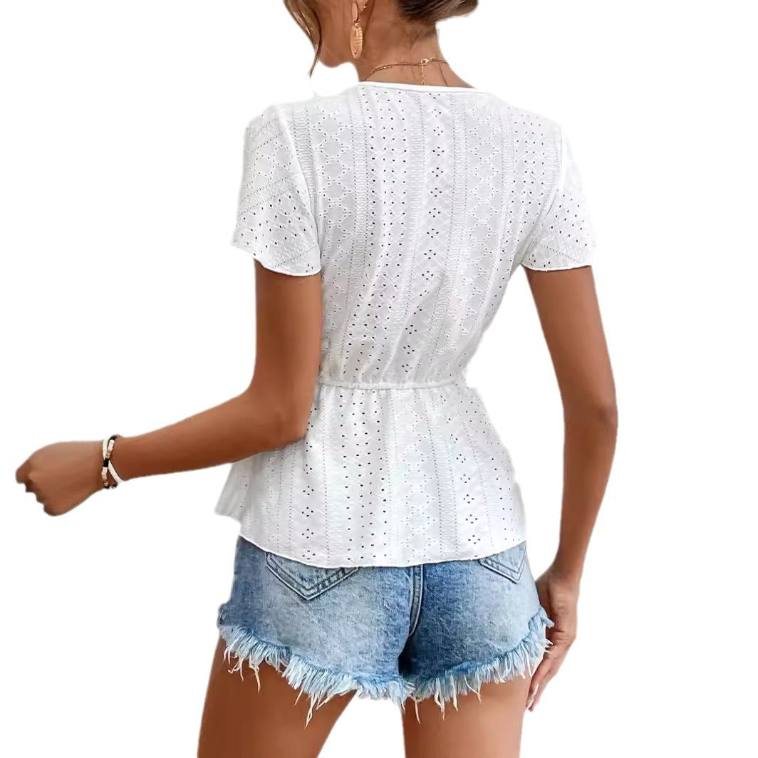 Woman wearing a white lace top and denim shorts on a white background