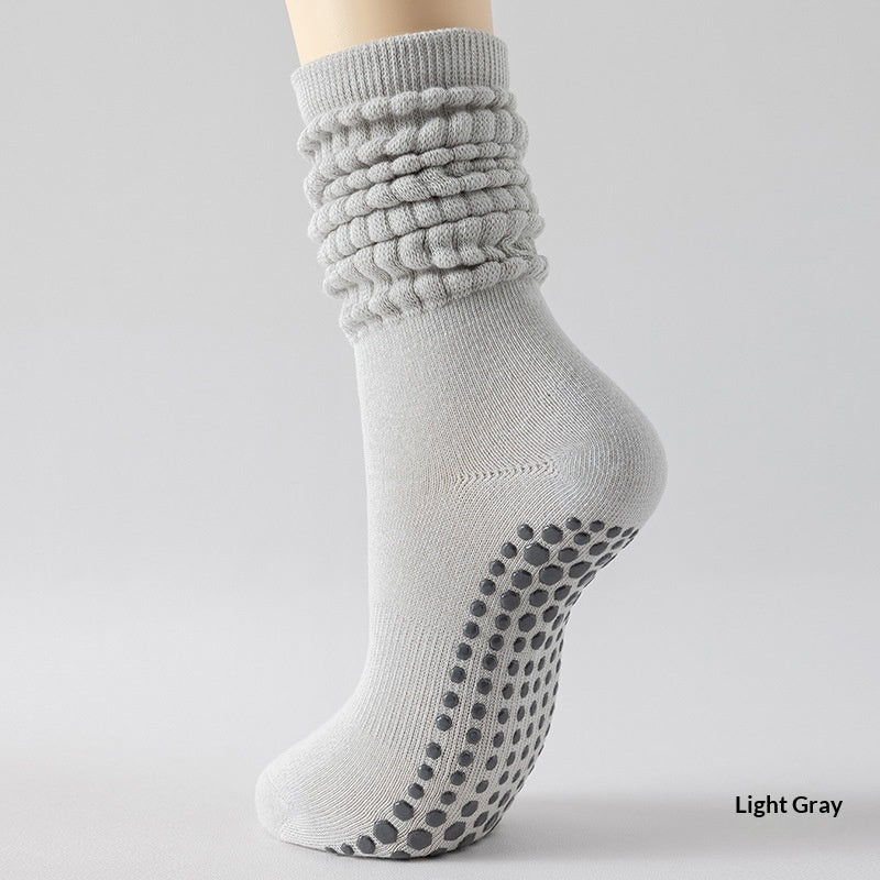 Light gray sock with textured top and black grip dots on a light gray background