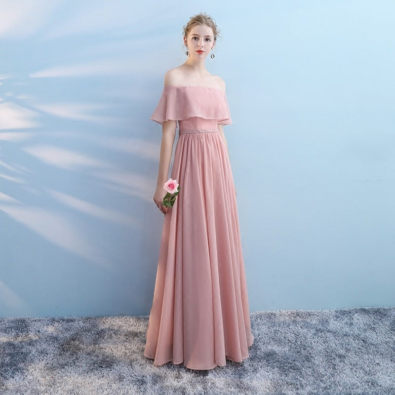 Woman in a pink dress holding a flower against a light blue background