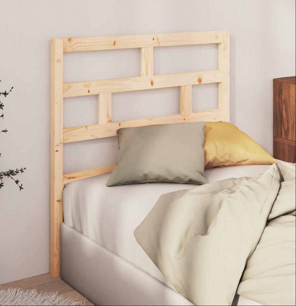 Bed with wooden headboard and pillows in a bedroom setting