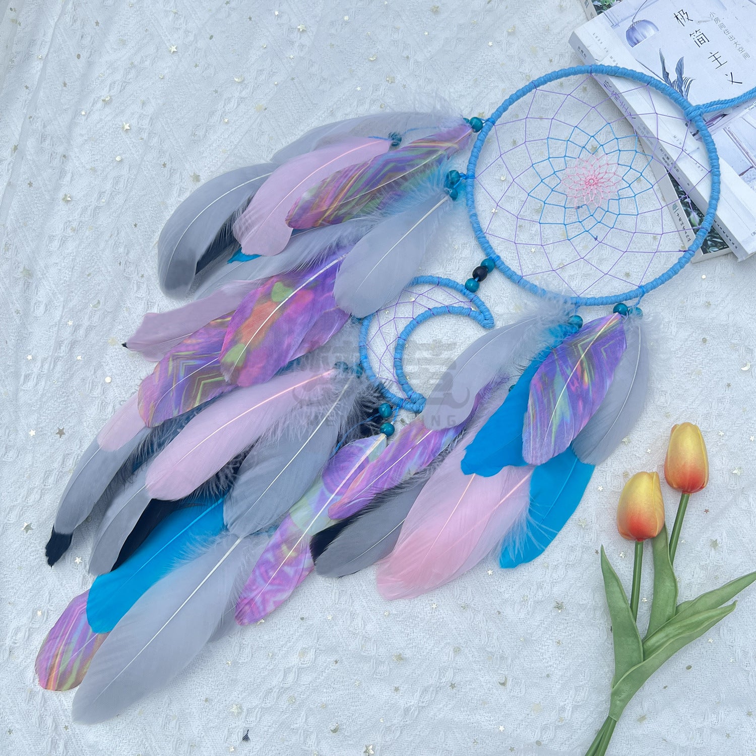 Decorative dreamcatcher with colorful feathers on a textured surface with tulips.