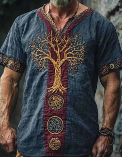 Man wearing a blue t-shirt with a tree of life design against a natural background