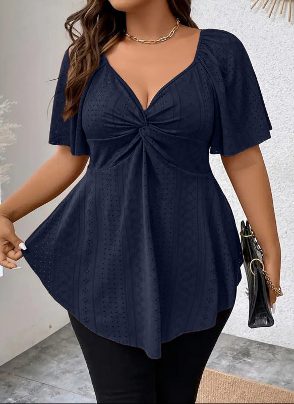 Navy blue top with a knot detail worn by a person on a light gray background