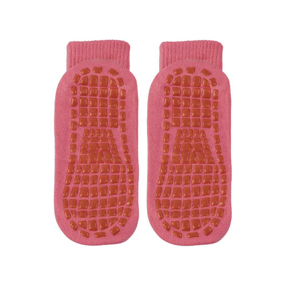 Pair of pink slipper socks with textured sole on a white background