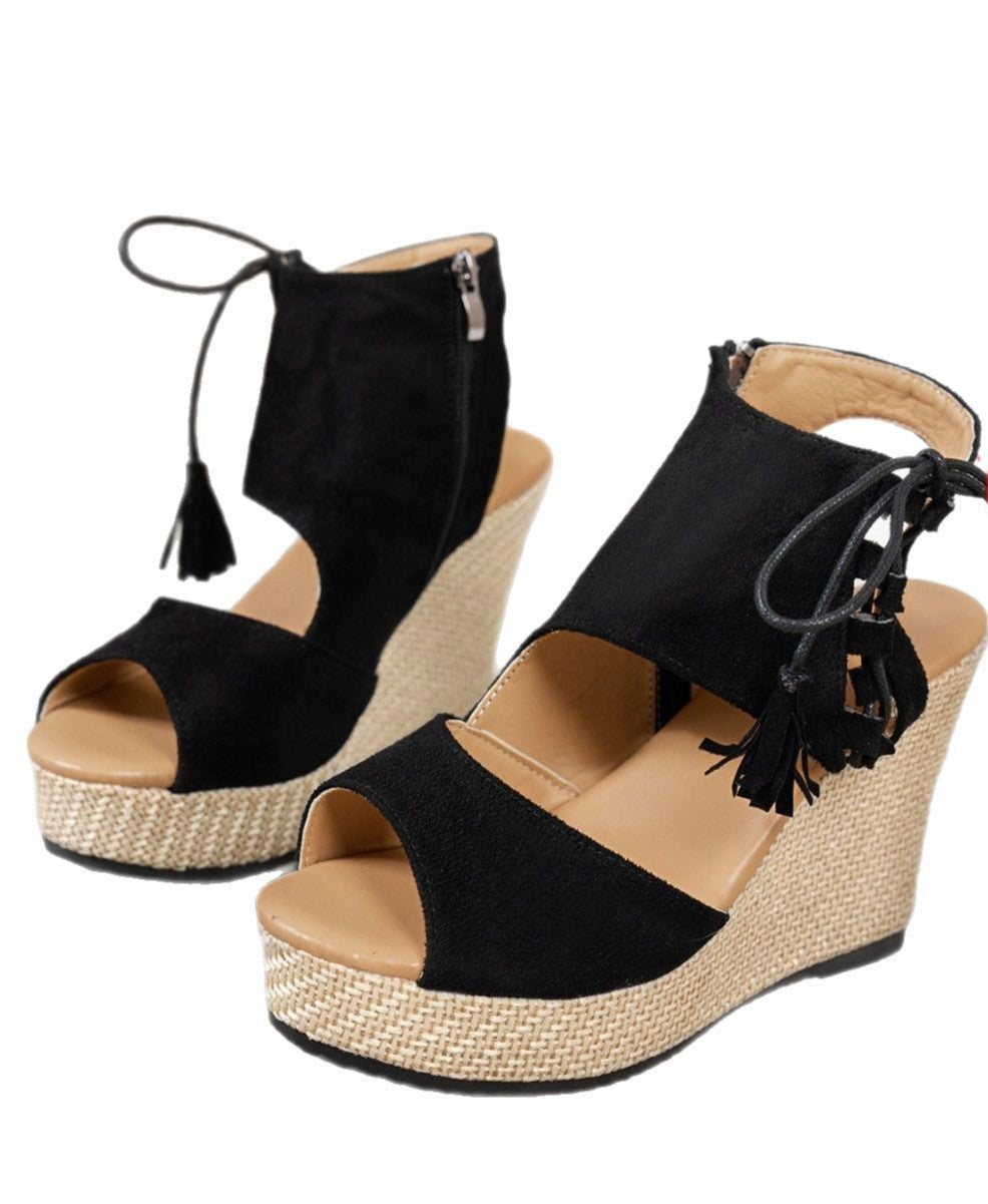 Black wedge sandals with tassels on a white background