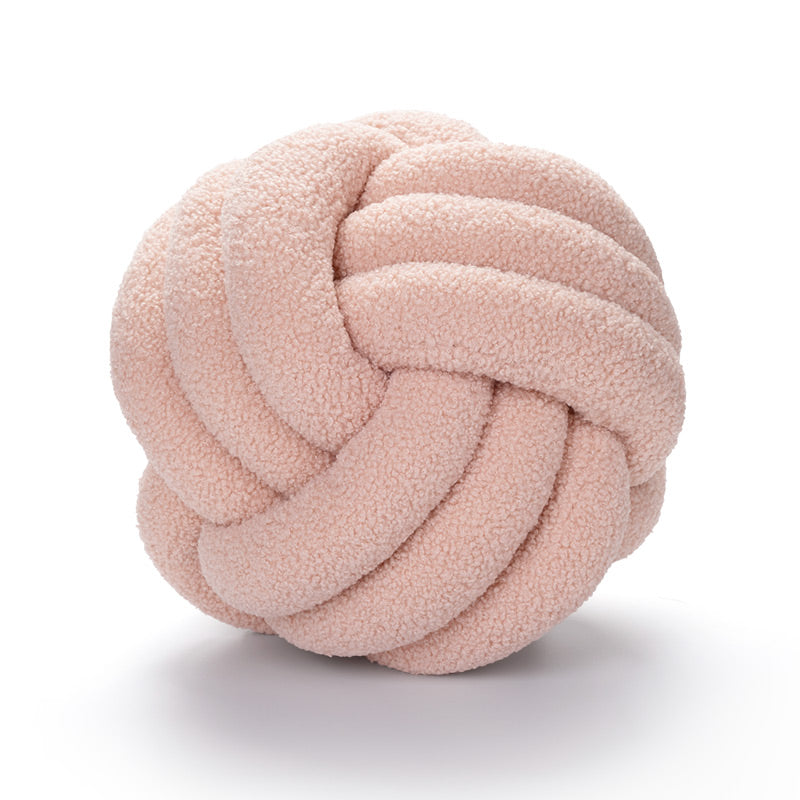 Pink knotted ball toy on a white background