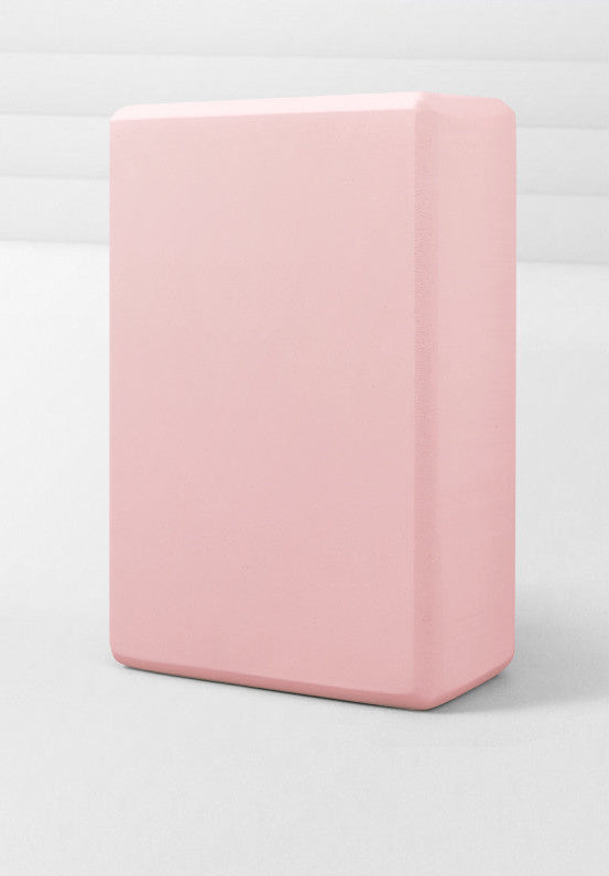Pink yoga block on a white background