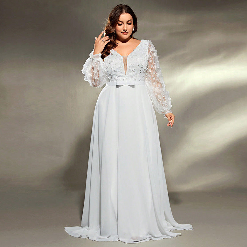 Woman wearing a white lace wedding dress against a neutral background
