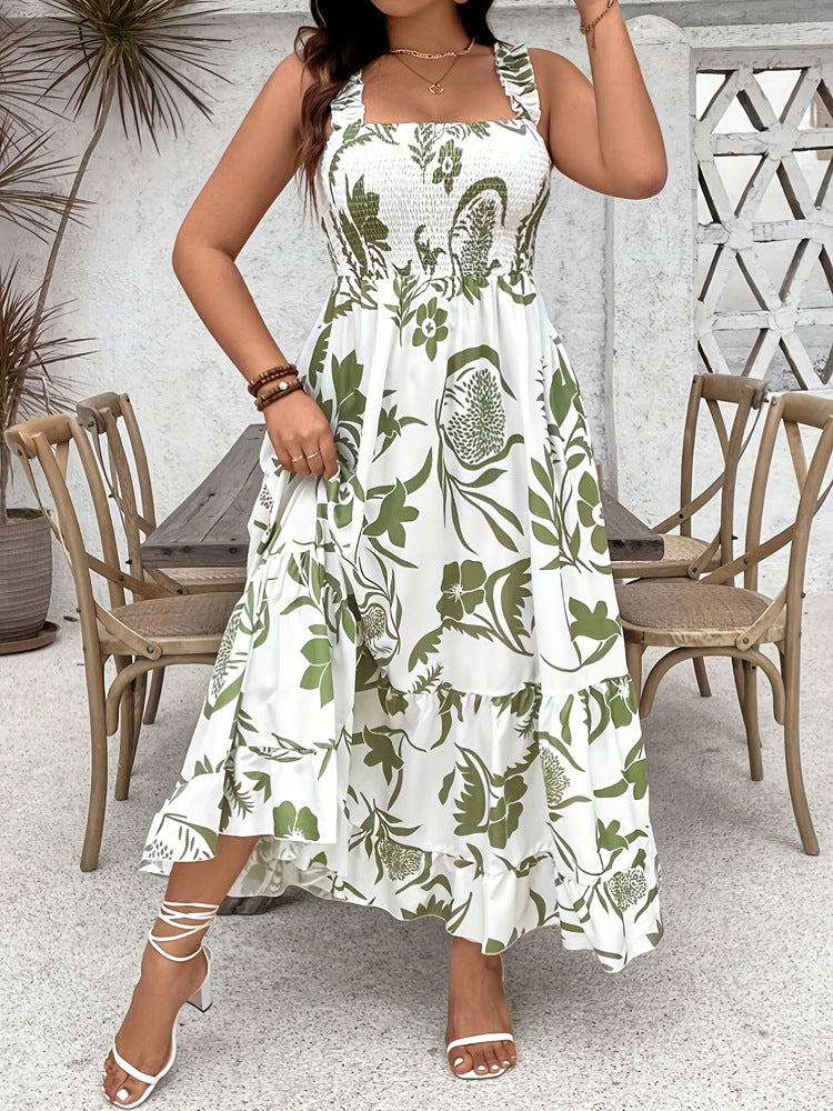Woman wearing a white dress with green floral pattern in an outdoor setting.