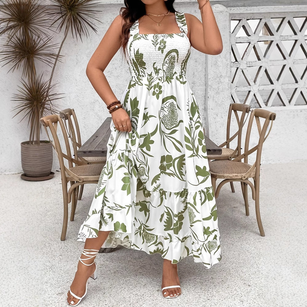 Woman wearing a white dress with green floral pattern in an outdoor setting.