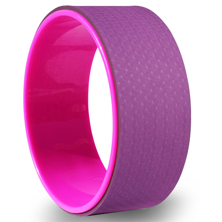 Purple and pink yoga wheel on a white background