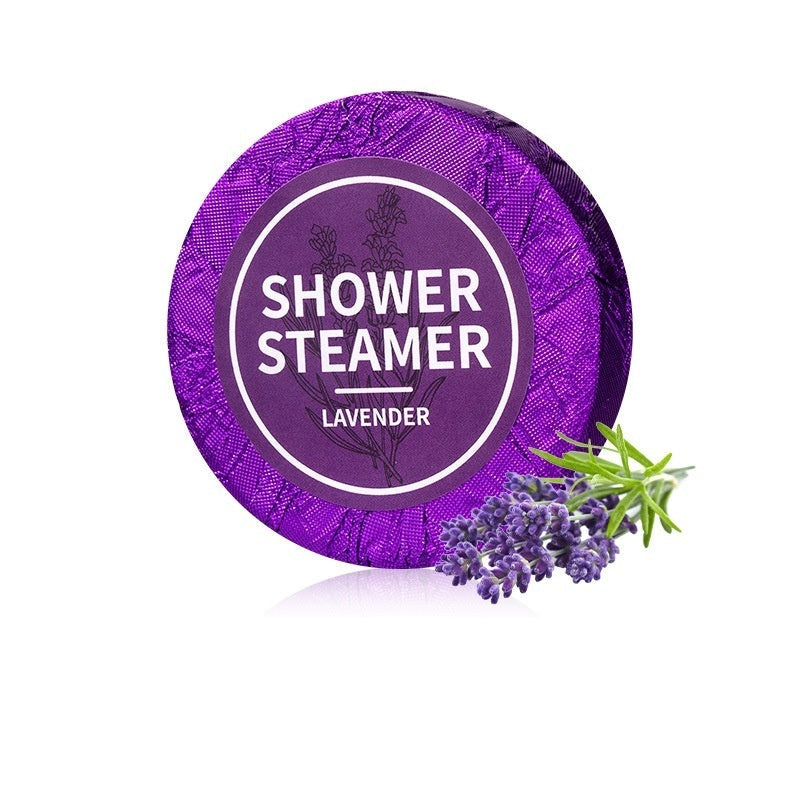 Purple shower steamer labeled 'Shower Steamer Lavender' with lavender flowers on a white background