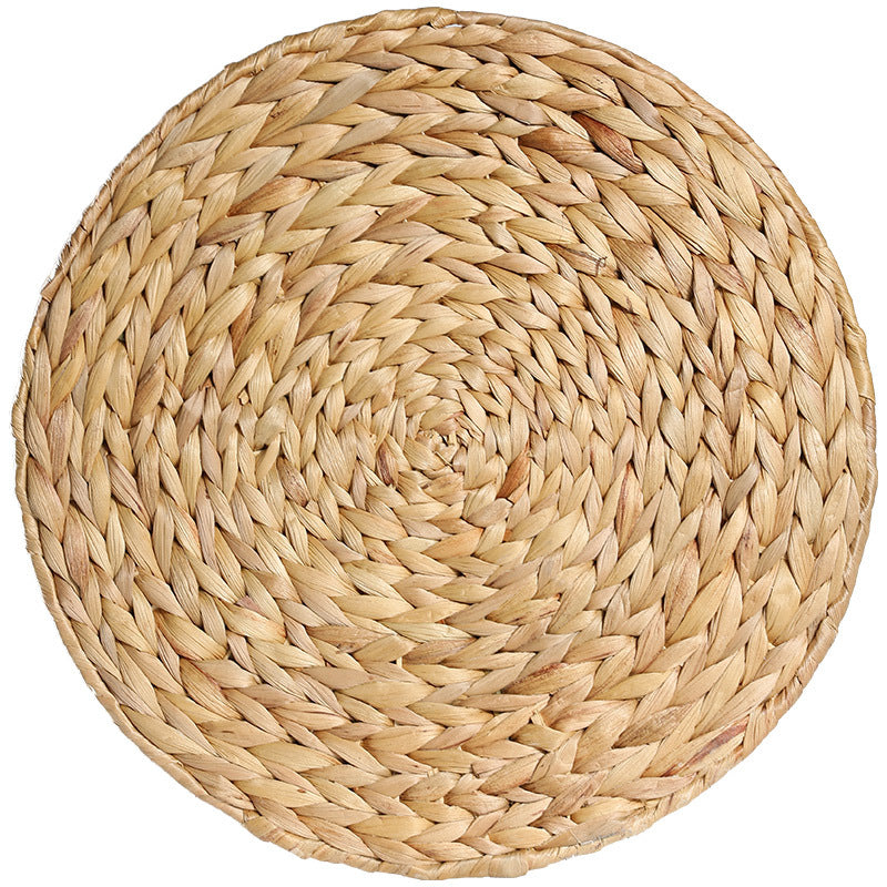 Round woven placemat made of natural materials on a white background