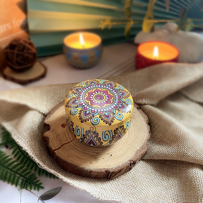 Decorative candle holder with mandala design on a wooden surface with candles in the background.