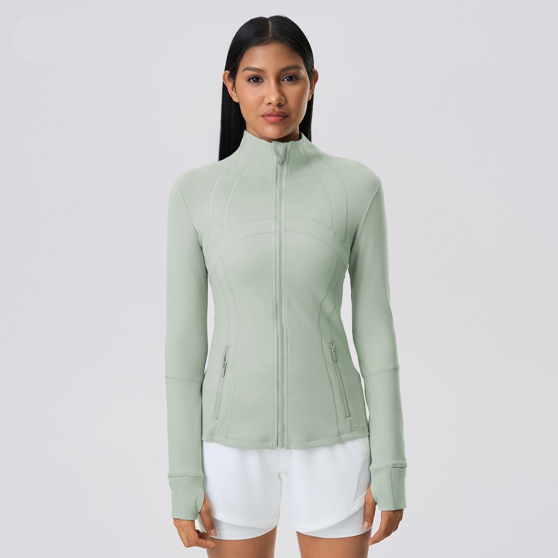 Woman wearing a light green jacket on a white background