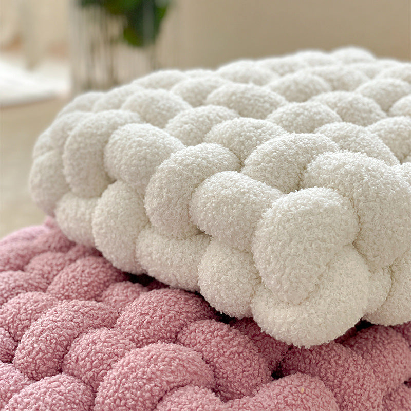 Stack of textured pink and white rugs on a neutral background