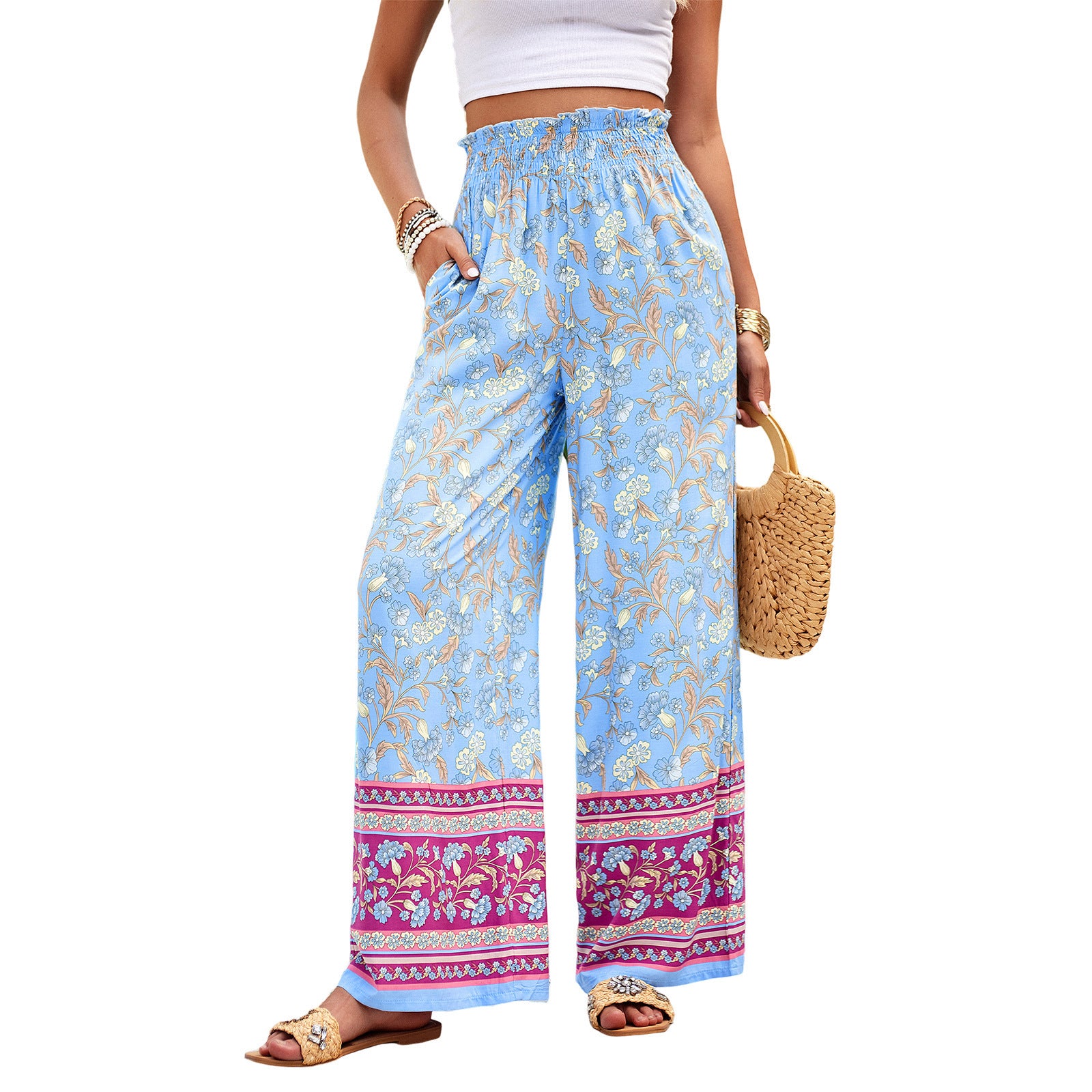 Woman wearing blue floral wide-leg pants with a white top on a white background
