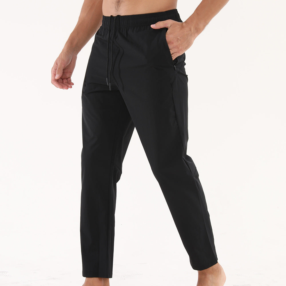 Black pants worn by a person on a white background