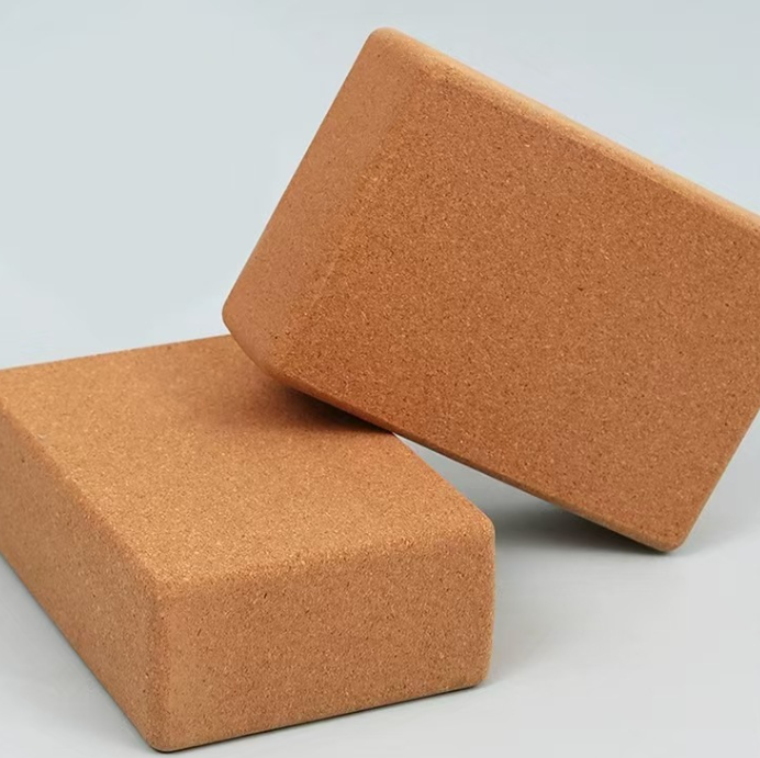 Two brown cork yoga blocks on a light gray background