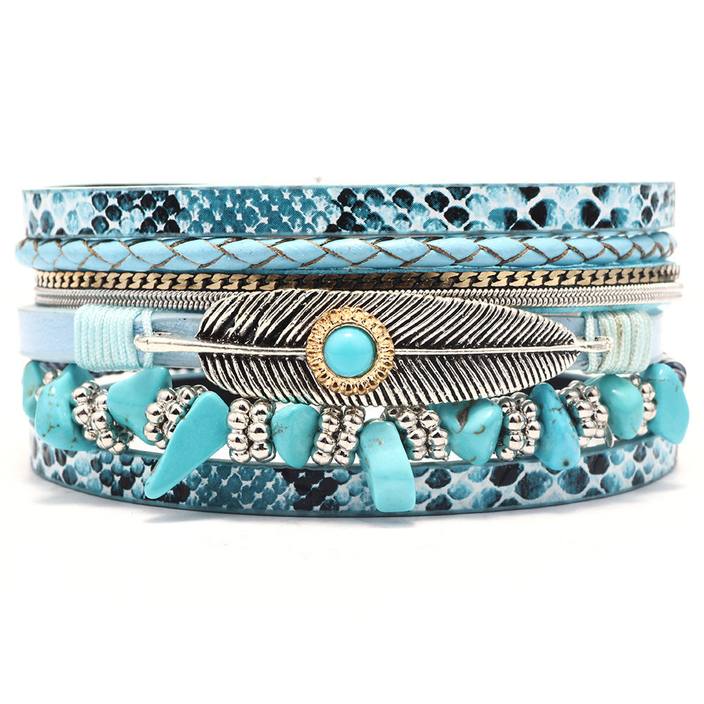 Stack of blue patterned bracelets with feather design on a white background