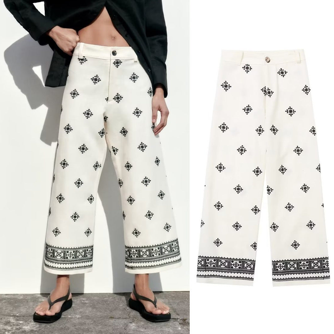 White pants with black geometric patterns worn by a person on a white background