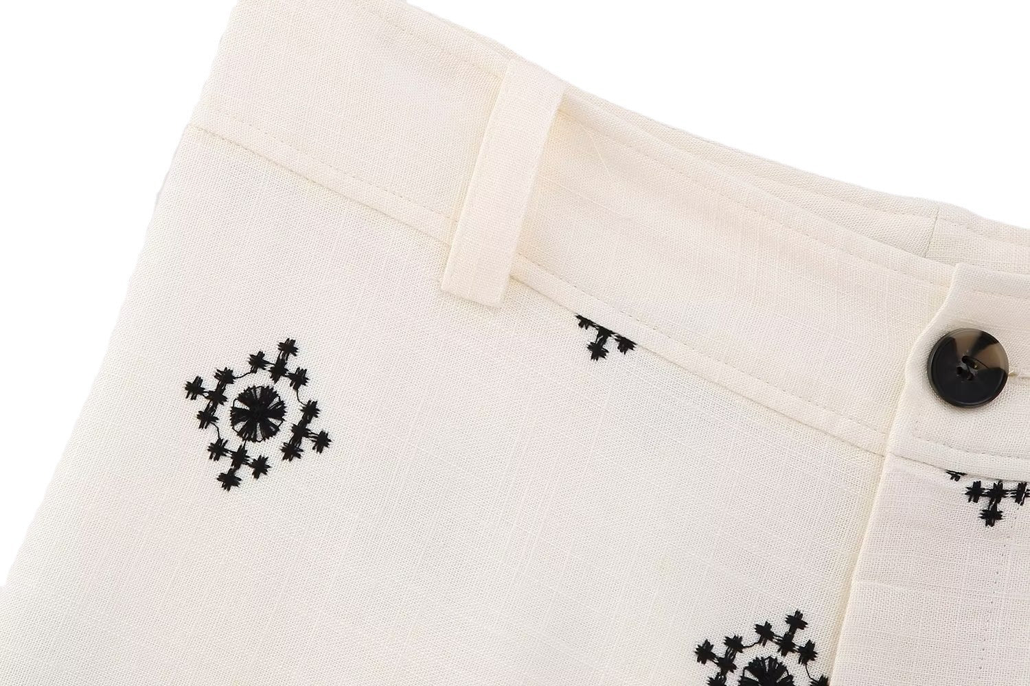 Close-up of white pants with black floral patterns on a white background