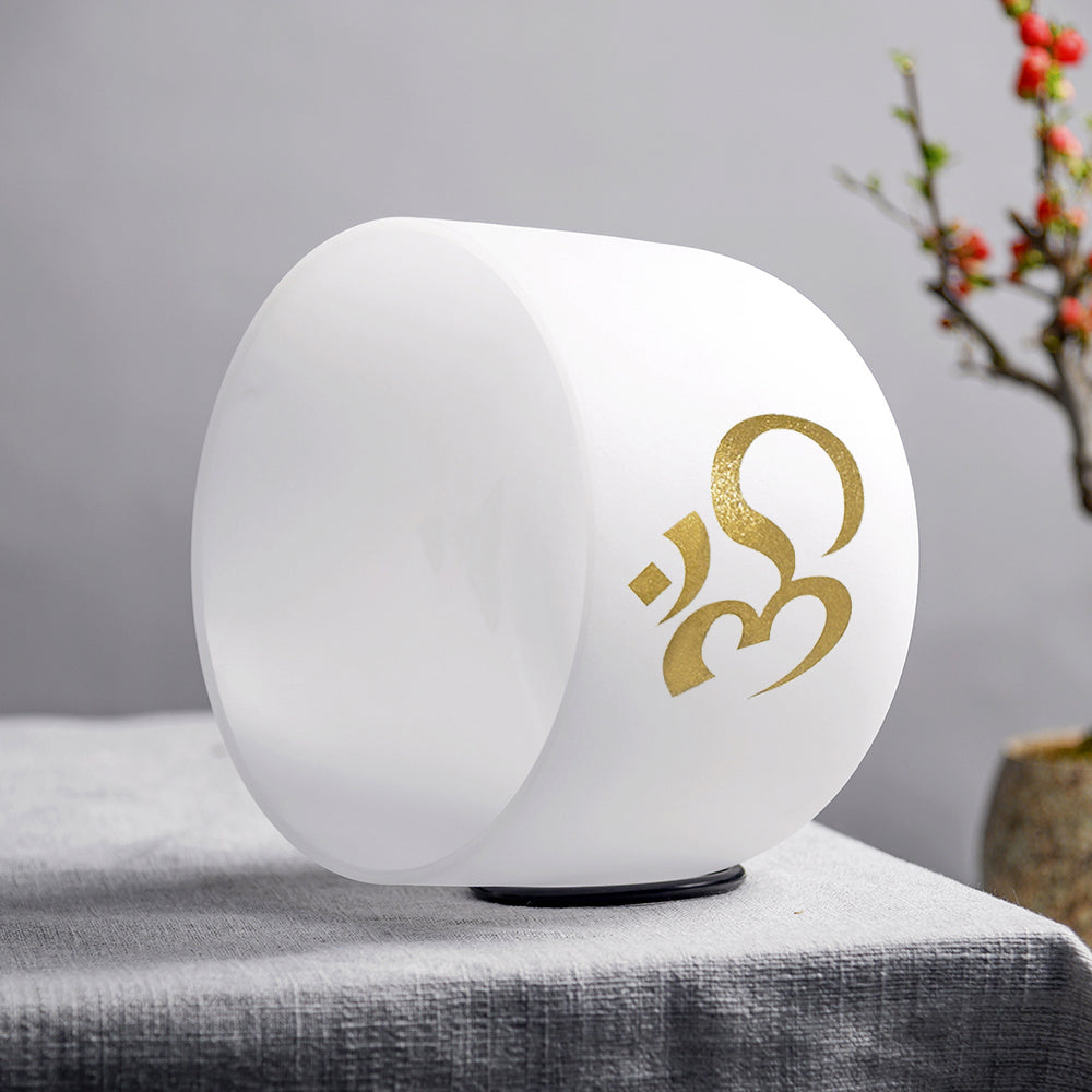 White spherical lamp with gold symbol on a gray surface with a blurred background