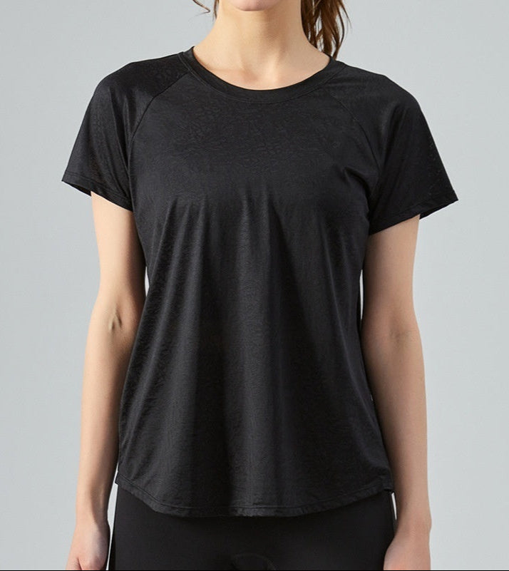 Black t-shirt worn by a person on a gray background